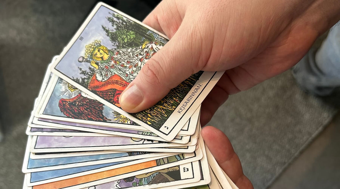 Manliga händer som bläddrar mellan olika tarotkort