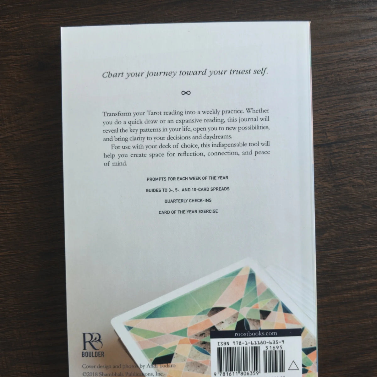 Baksidan på The Fountain Tarot Journal i ljusgrått med presentationstext och ett kort med geometrisk baksida i hörnet